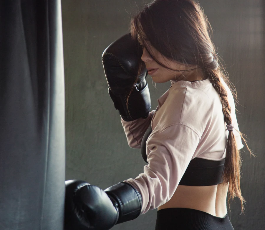 Foto ilustrativa de uma atleta treinando Boxe com saco de pancadas